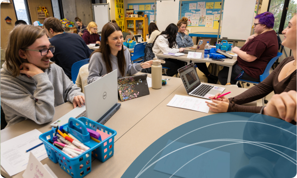 Students in Education Classroom working On Computers and Laughing