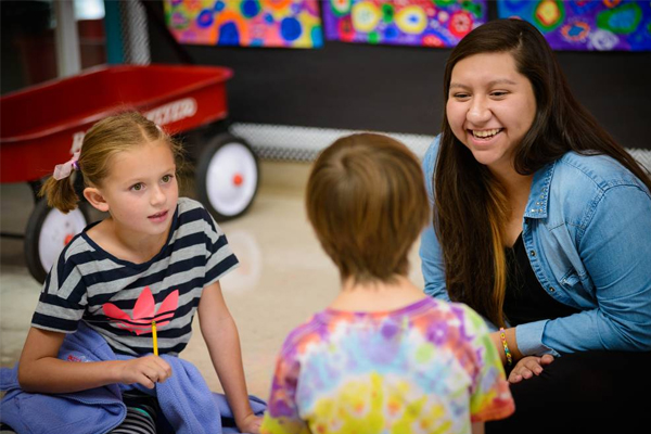 Early Childhood Education Program Student Laughing WIth Children