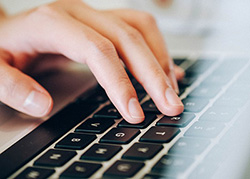 Photo of hands on a computer keyboard