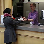 Photo of a student checking out a book at the Circulation Desk