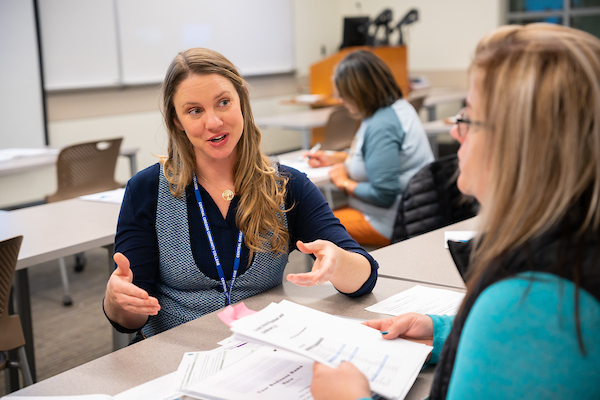 Small business advisor meets with a student at a table