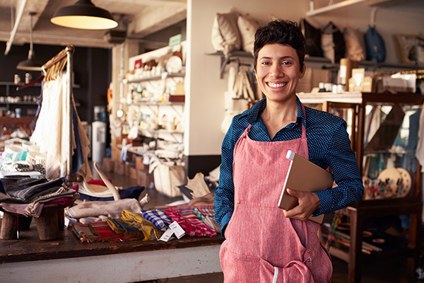 Business Administration female shop owner in pink apronr monitors