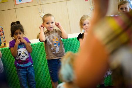 Young children playing a game with early childhood education student instructor