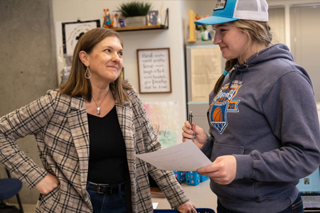 Meet Education Faculty - A faculty member discissuing a paper with a student.