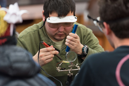 Career minded Engineering and Physics student soldering a circuit board