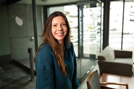 Erin, a woman with long brown hair, smiles at the camera.