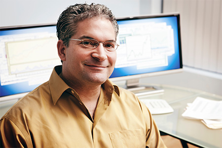 Man with glasses smiling at the camera.