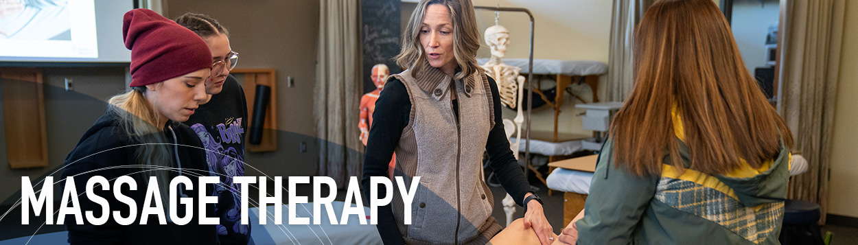 Woman teaching students massage therapy techniques.