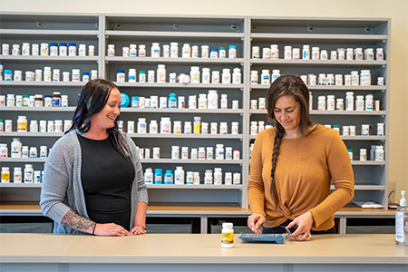 Two pharmacy tech faculty members working in the classroom together.