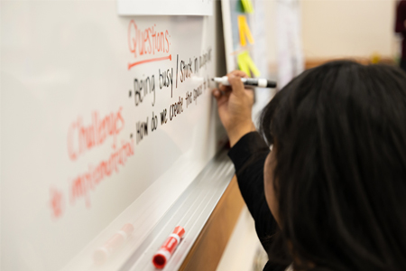 Sociology student writing on a whiteboard