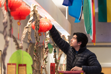 Man on ladder hanging world culture paper lantern